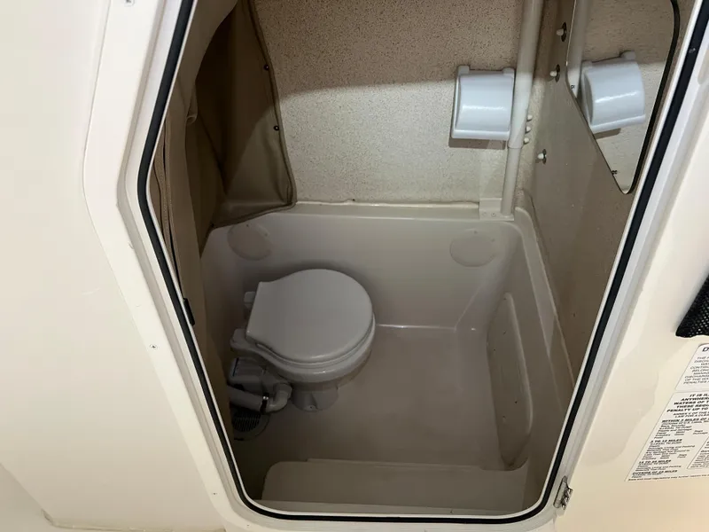 Slide: The Image of 2023 Sea Chaser 30HFC boat interior bathroom with toilet and toilet paper holder. - 16