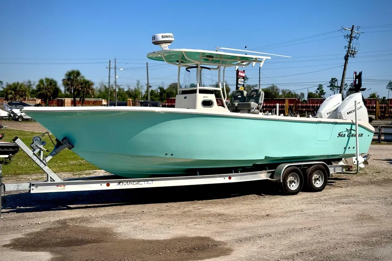 Slide: The Image of 2023 Sea Chaser 30 HFC CC boat on trailer, light blue hull, parked outdoors. - 2