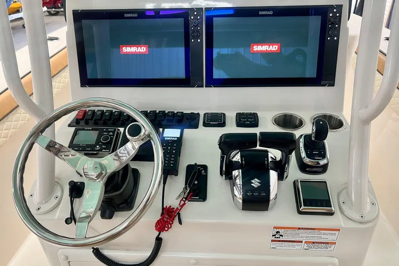 Slide: The Image of 2023 Sea Chaser 30 HFC CC boat dashboard with dual Simrad displays and controls. - 23