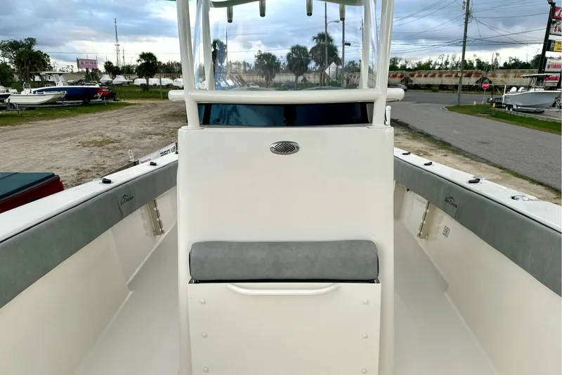 Slide: The Image of 2023 Sea Chaser 30 HFC CC boat interior with seating and console, parked outdoors. - 42