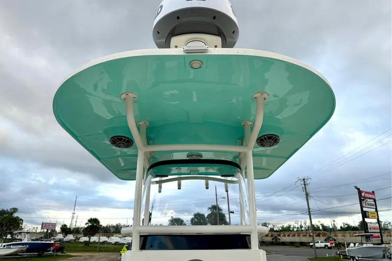 Slide: The Image of 2023 Sea Chaser 30 HFC CC boat with teal hardtop and speakers, parked outdoors. - 43