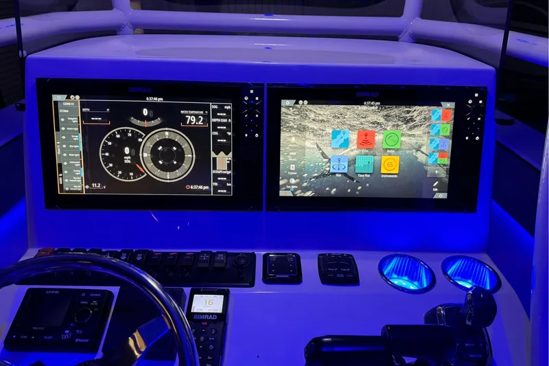 Slide: The Image of 2023 Sea Chaser 30 HFC CC dashboard with dual Simrad displays and illuminated controls. - 51