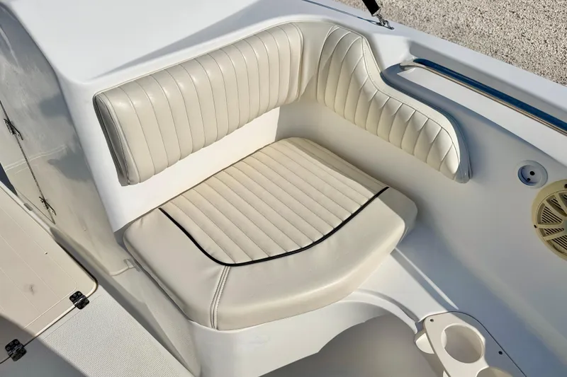 Slide: The Image of 2009 Mako 216 Dual Console boat seat with white cushioned upholstery. - 11