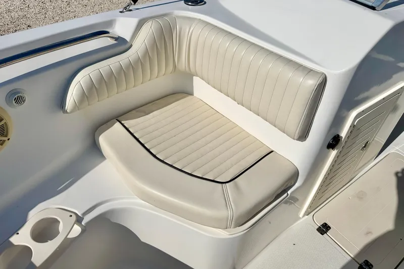 Slide: The Image of 2009 Mako 216 Dual Console boat interior with cushioned seating and storage compartment. - 12