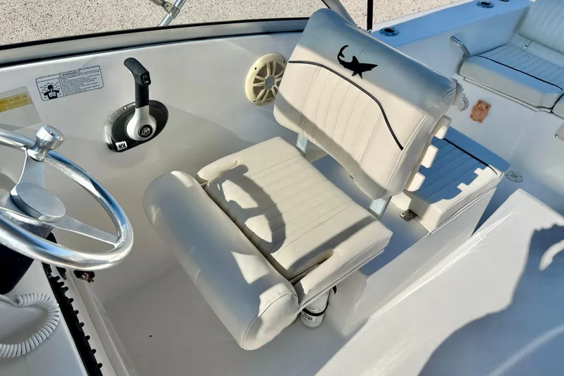 Slide: The Image of 2009 Mako 216 Dual Console boat interior with steering wheel and cushioned seating. - 13