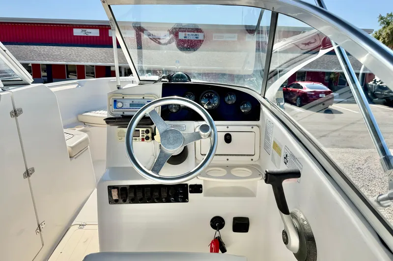 Slide: The Image of 2009 Mako 216 Dual Console boat dashboard with steering wheel and controls. - 14