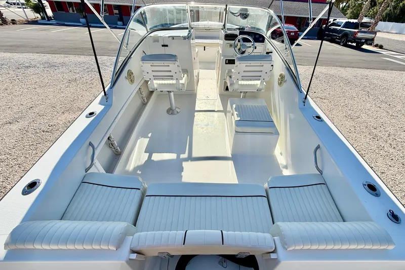 Slide: The Image of 2009 Mako 216 Dual Console boat interior with white seating and steering wheel. - 21