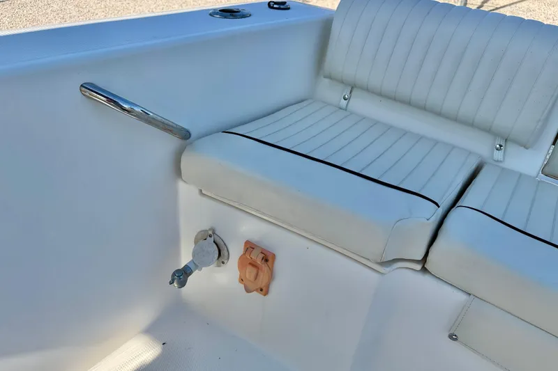 Slide: The Image of 2009 Mako 216 Dual Console boat interior with white cushioned seating. - 24