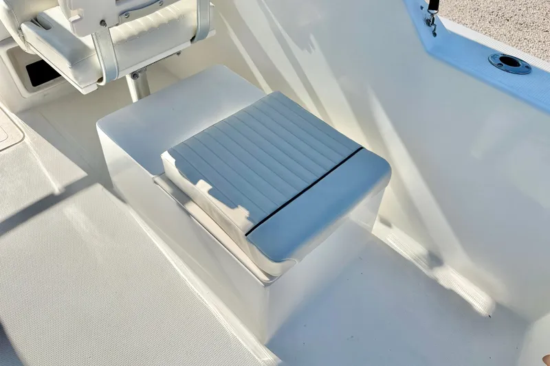 Slide: The Image of 2009 Mako 216 Dual Console boat interior with white seating and storage compartment. - 25