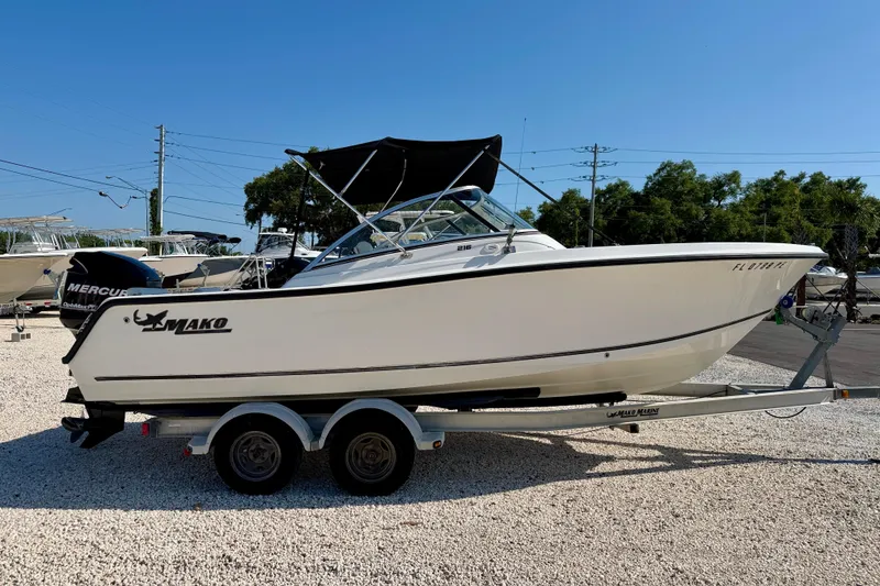 Slide: The Image of 2009 Mako 216 Dual Console boat on trailer, parked outdoors under clear blue sky. - 4