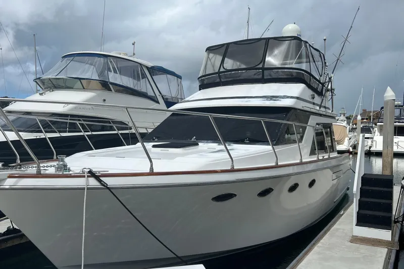 The Image of 1990 Ocean Alexander 42 yacht docked at marina under cloudy sky. - 0