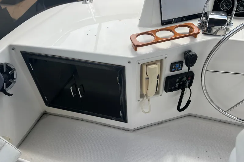 Slide: The Image of Control panel of a 1990 Ocean Alexander 42 yacht with steering wheel and communication devices. - 10