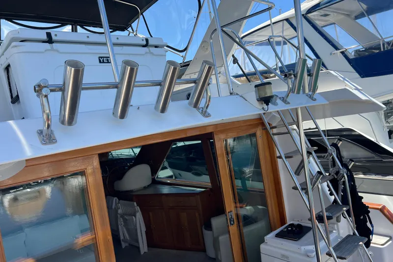 Slide: The Image of 1990 Ocean Alexander 42 yacht with rod holders and ladder, docked at a marina. - 15