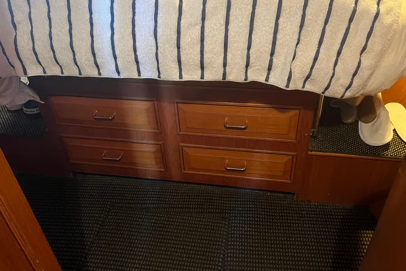 Slide: The Image of Interior of 1990 Ocean Alexander 42 yacht with wooden drawers and striped bedding. - 29