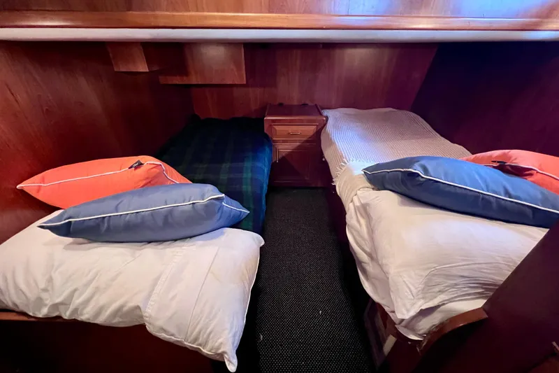 Slide: The Image of Cozy twin cabin in 1990 Ocean Alexander 42 yacht with wooden interior and colorful pillows. - 42