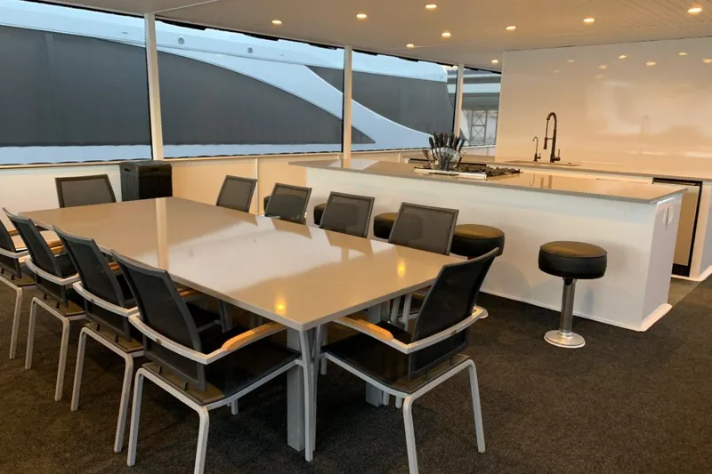 Slide: The Image of Luxurious yacht dining area with modern table, chairs, and sleek kitchen, Adonia Utopia Trip 2019. - 13