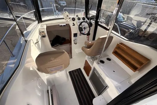 Slide: The Image of 2018 Jeanneau NC Sport 695 boat interior with steering wheel and seating area. - 15