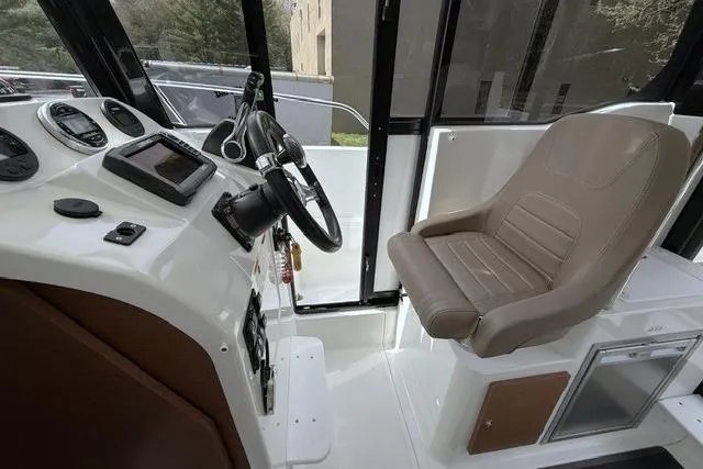 Slide: The Image of Interior of 2018 Jeanneau NC Sport 695 boat, featuring helm and captain's chair. - 16
