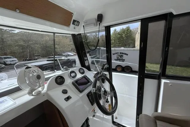 Slide: The Image of Interior view of 2018 Jeanneau NC Sport 695 boat cockpit with steering wheel and controls. - 17