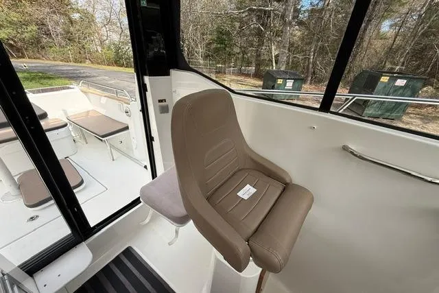 Slide: The Image of 2018 Jeanneau NC Sport 695 interior with brown captain's chair and outdoor seating. - 20