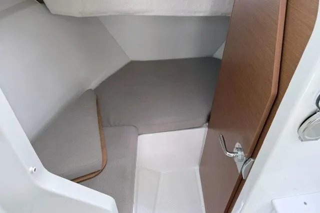 Slide: The Image of 2018 Jeanneau NC Sport 695 cabin interior with cozy gray bedding and wooden door. - 21