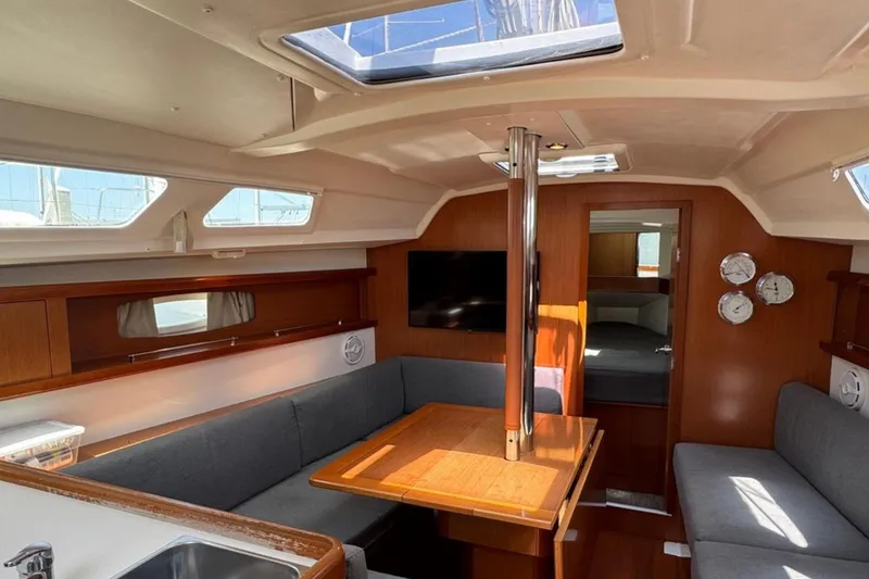 Slide: The Image of Interior of a 2010 Beneteau Oceanis 37 sailboat with cozy seating and wooden finishes. - 10