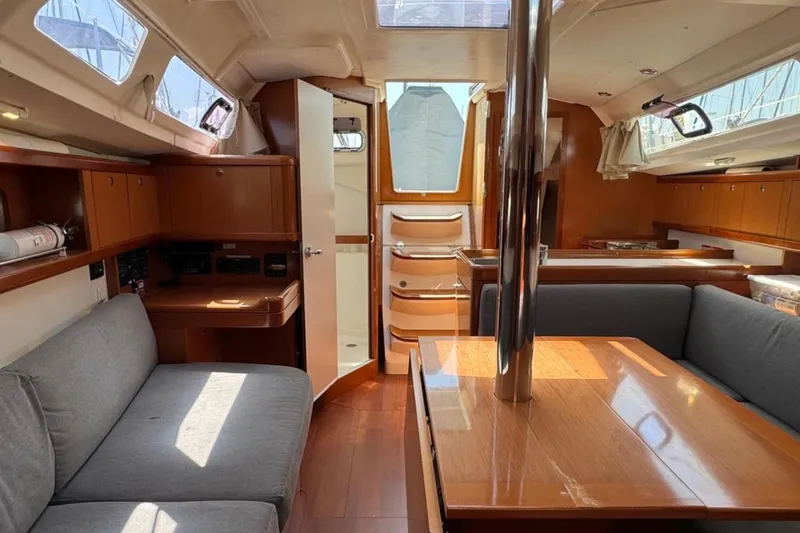Slide: The Image of Interior of 2010 Beneteau Oceanis 37 sailboat, featuring cozy seating and wooden finishes. - 15