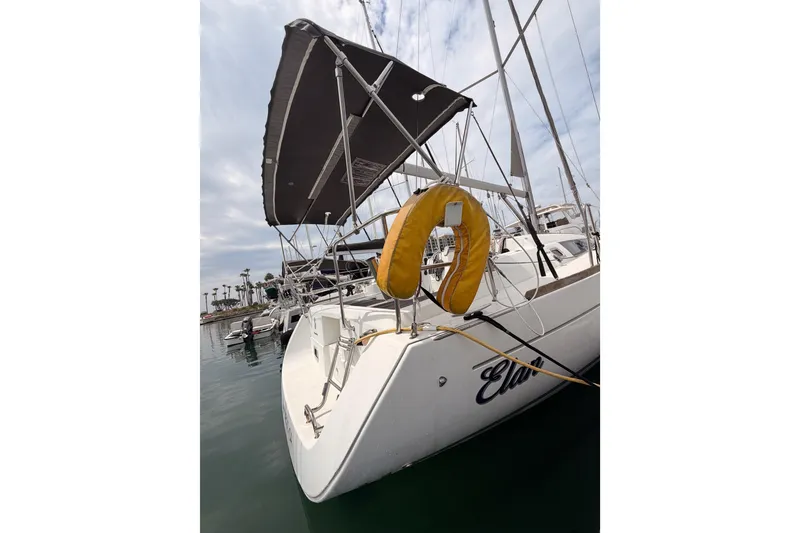 Slide: The Image of 2010 Beneteau Oceanis 34 sailboat docked, featuring a yellow life ring and canopy. - 22