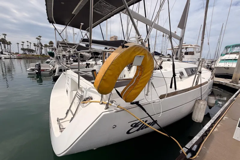 Slide: The Image of Beneteau Oceanis 34 sailboat, 2010 model, docked at a marina with lifebuoy visible. - 23