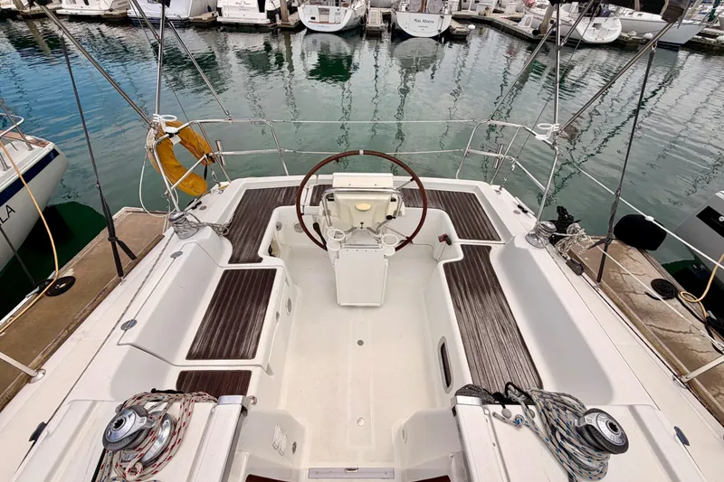 Slide: The Image of Cockpit view of a 2010 Beneteau Oceanis 34 sailboat docked at a marina. - 30