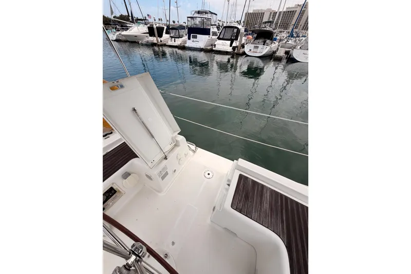 Slide: The Image of 2010 Beneteau Oceanis 34 yacht deck view in marina, showcasing open storage compartment. - 32