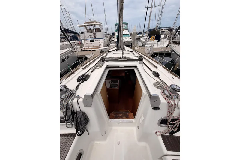 Slide: The Image of Beneteau Oceanis 34 sailboat, 2010 model, docked at marina with open cabin entrance. - 37