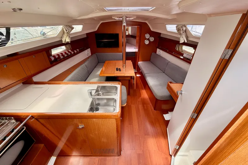 Slide: The Image of Interior of 2010 Beneteau Oceanis 34 sailboat with wood finish and cozy seating area. - 38