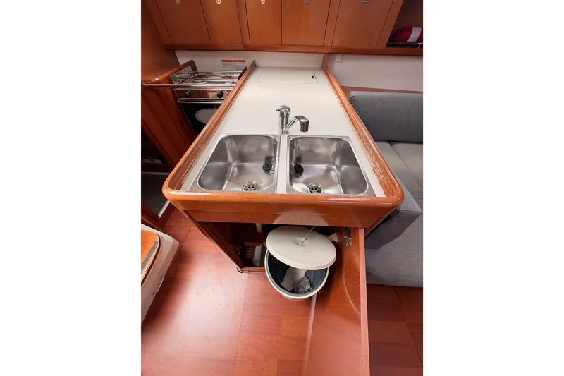 Slide: The Image of Galley kitchen in 2010 Beneteau Oceanis 34 yacht with dual sinks and wooden cabinetry. - 42