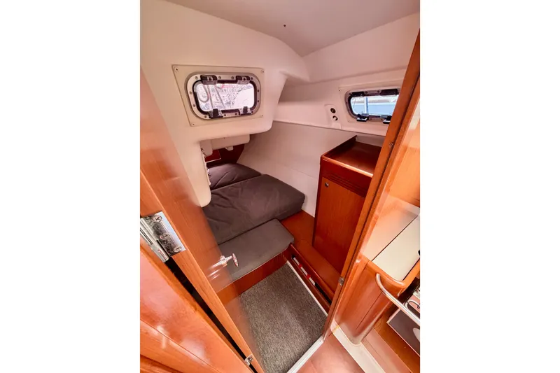 Slide: The Image of Cozy cabin interior of 2010 Beneteau Oceanis 34 sailboat with wooden finish and porthole. - 43