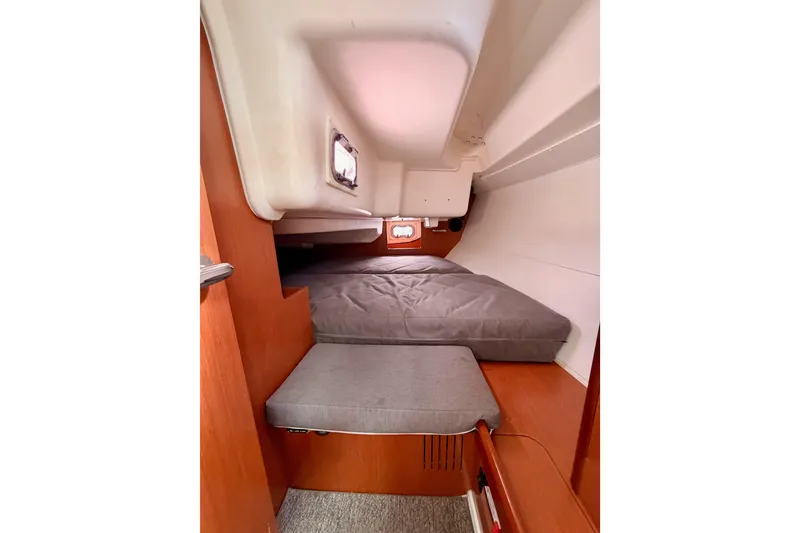 Slide: The Image of Interior cabin of 2010 Beneteau Oceanis 34 sailboat, featuring cozy sleeping area and wooden finishes. - 44