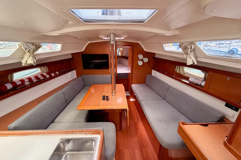 Slide: The Image of Interior of 2010 Beneteau Oceanis 34 sailboat with cozy seating and wooden finishes. - 50
