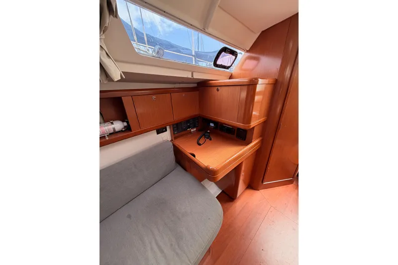 Slide: The Image of Interior of 2010 Beneteau Oceanis 34 sailboat with wooden cabinetry and seating area. - 52