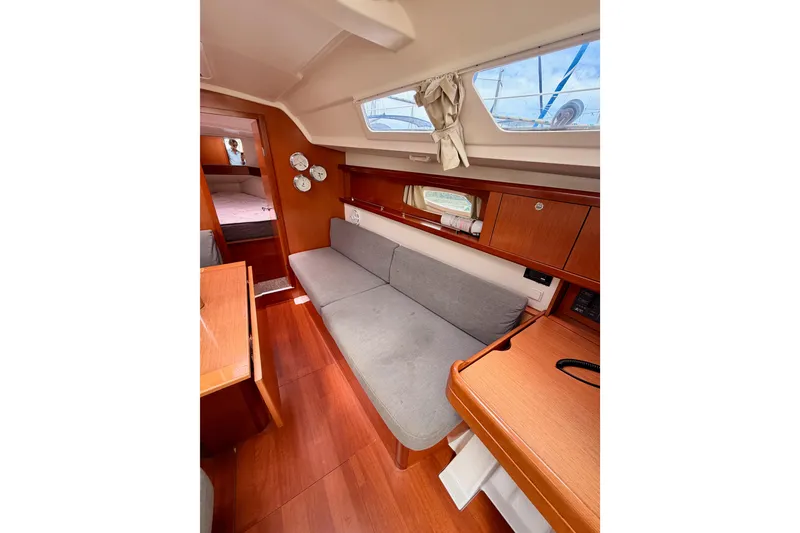 Slide: The Image of Interior of 2010 Beneteau Oceanis 34 sailboat with cozy seating and wooden finishes. - 57