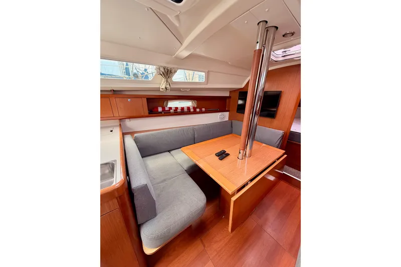 Slide: The Image of Interior of 2010 Beneteau Oceanis 34 sailboat with cozy dining area and wooden finishes. - 58