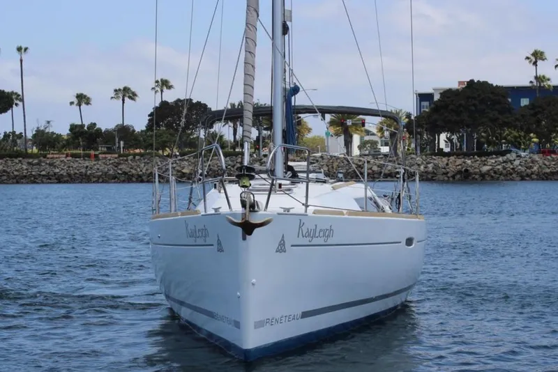 Slide: The Image of 2010 Beneteau Oceanis 37 sailboat on calm water near a rocky shoreline. - 6