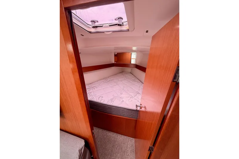 Slide: The Image of Cozy cabin interior of 2010 Beneteau Oceanis 34 sailboat with skylight and wooden finish. - 60