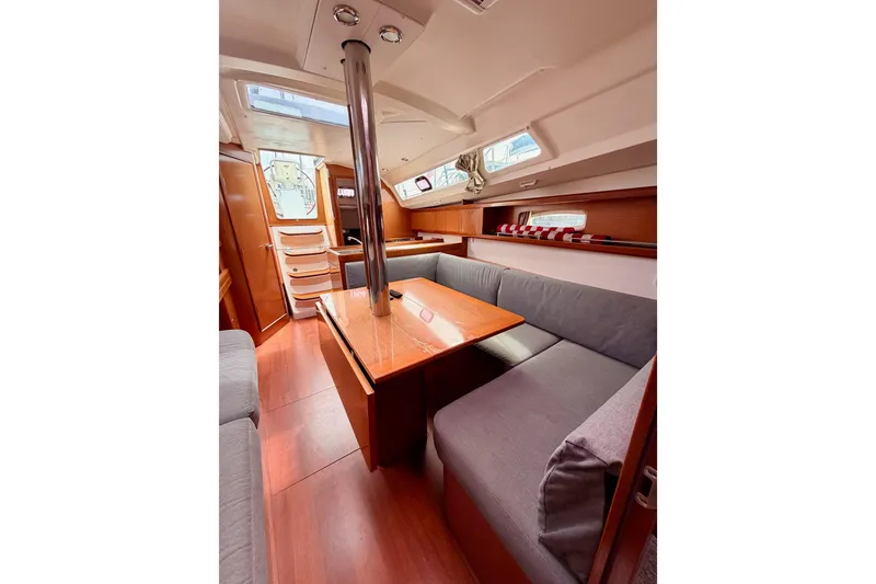 Slide: The Image of Interior of 2010 Beneteau Oceanis 34 sailboat, featuring cozy seating and wooden finishes. - 65