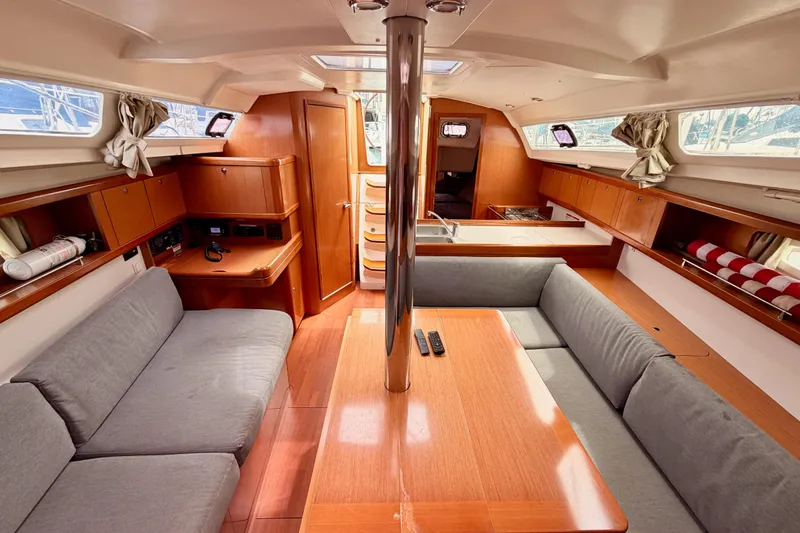 Slide: The Image of Interior of 2010 Beneteau Oceanis 34 sailboat with cozy seating and wooden finishes. - 66