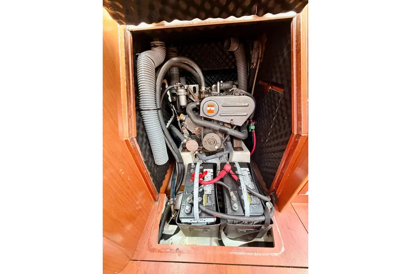 Slide: The Image of Engine compartment of a 2010 Beneteau Oceanis 34 sailboat, featuring visible batteries and hoses. - 70