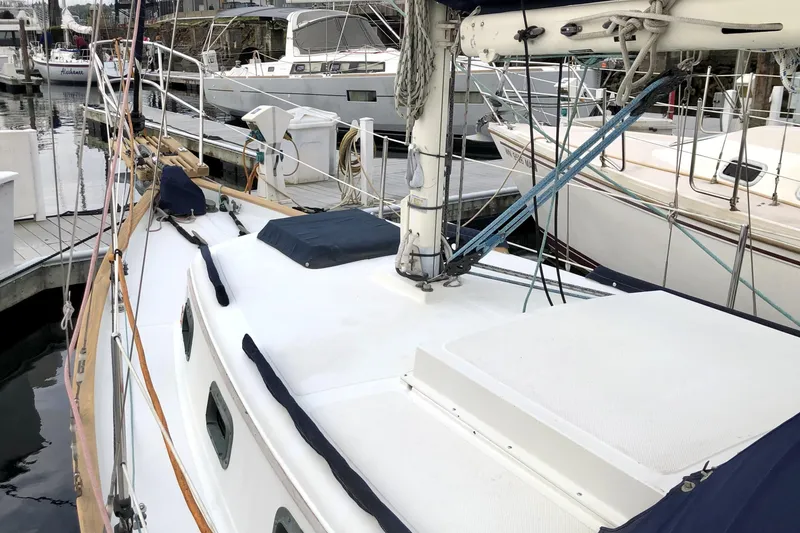 Slide: The Image of 1989 Pacific Seacraft Dana 24 sailboat docked at a marina, showcasing deck and rigging. - 4