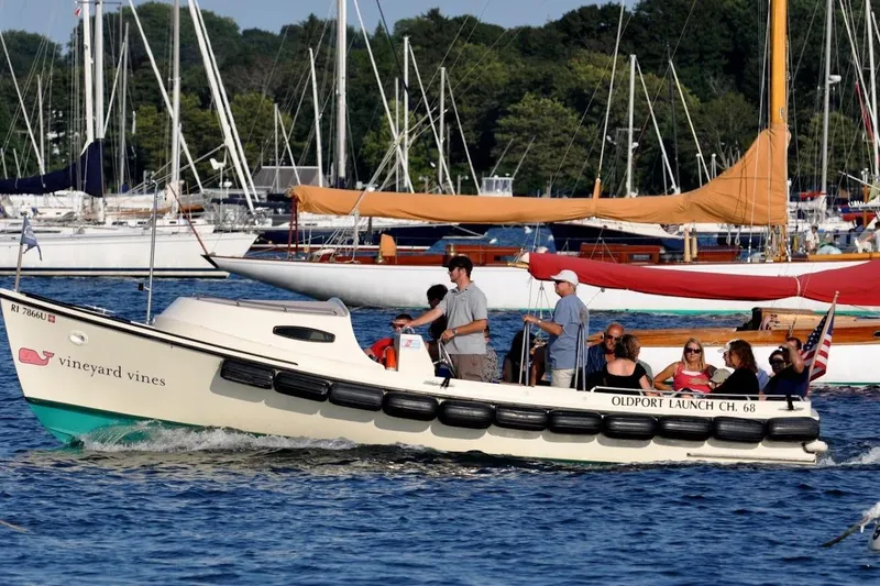 Slide: The Image of A 2026 Oldport Launch boat cruising with passengers in a scenic marina setting. - 3