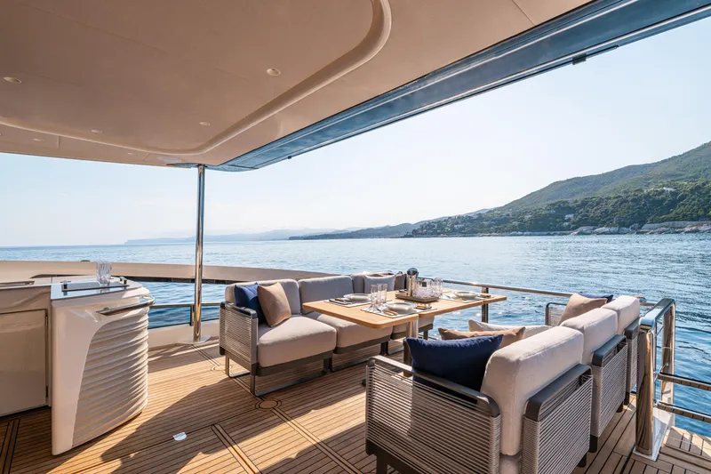 Slide: The Image of Luxurious 2026 Absolute 62' Navetta yacht deck with elegant dining area and scenic ocean view. - 13