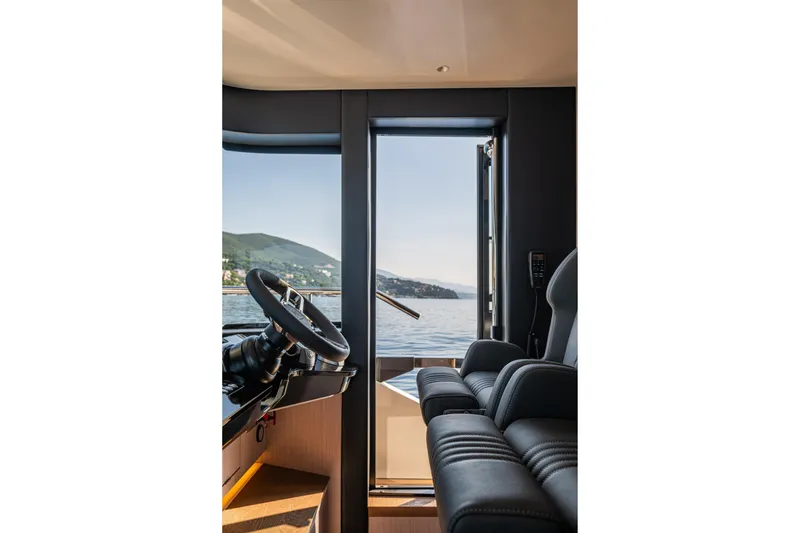 Slide: The Image of Interior view of 2026 Absolute 62' Navetta yacht helm with scenic ocean backdrop. - 20