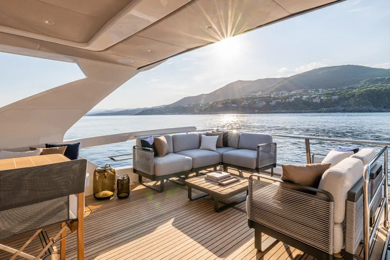 Slide: The Image of Luxurious 2026 Absolute 62' Navetta yacht deck with elegant seating, ocean view, and sunset. - 8